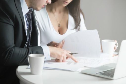 Businessman and businesswoman at office desk, working together w